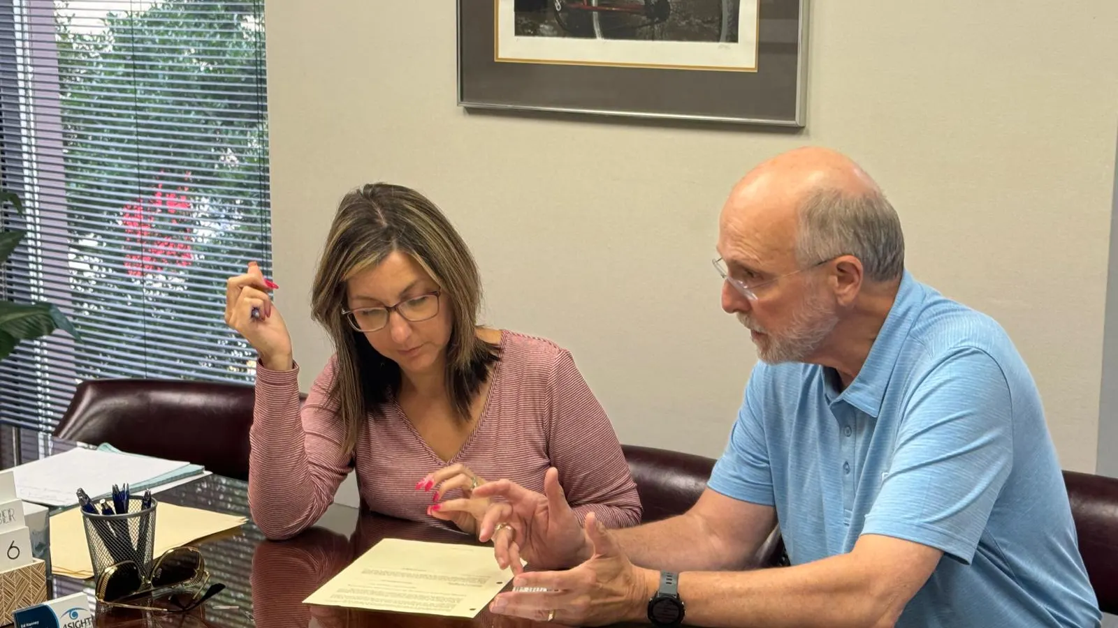 Ed Nanney walking a guest through a planning document at the conference table
